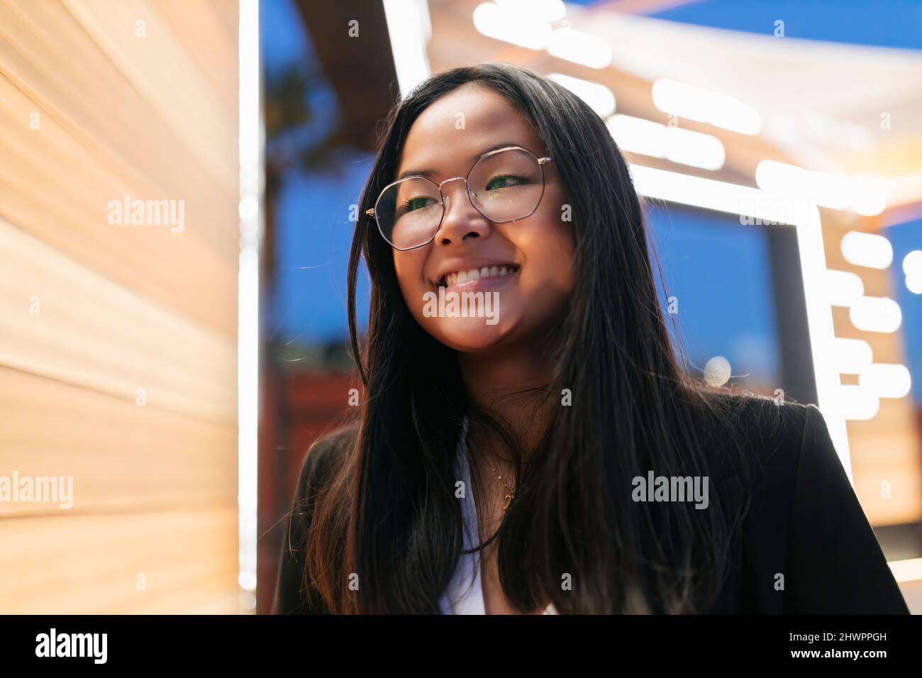 Jeune femme d'affaires souriante avec des lunettes et de longs cheveux noirs Banque D'Images