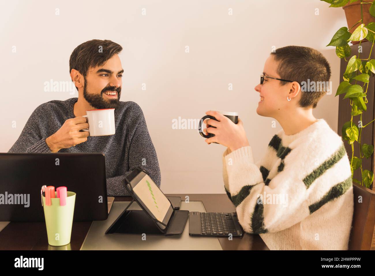 Des collègues heureux de boire du café à la réception dans un petit bureau Banque D'Images