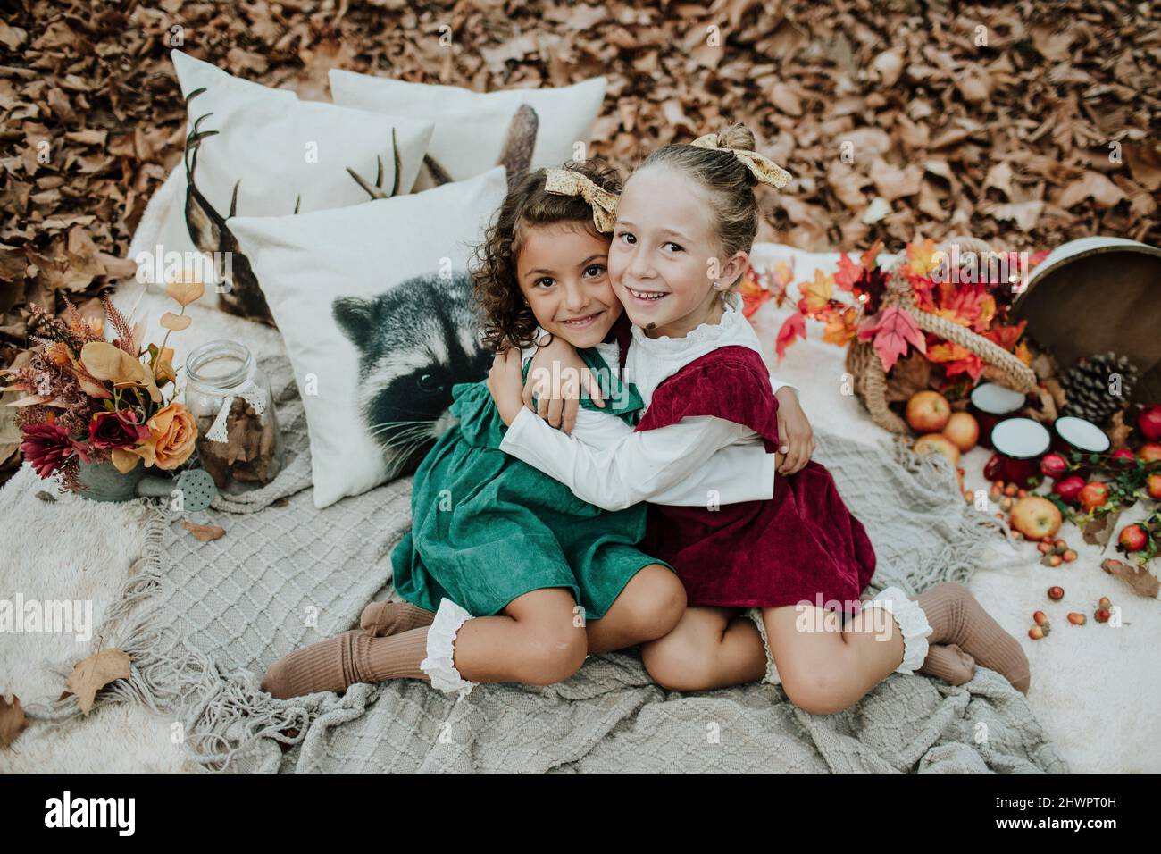 Des filles souriantes s'embrassent en automne dans la forêt Banque D'Images