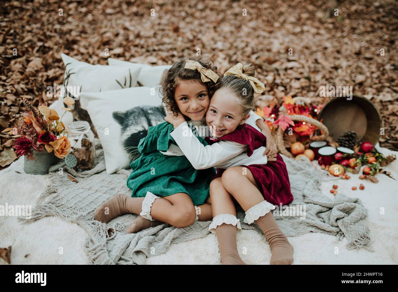Des filles heureuses au pique-nique embrassant dans la forêt d'automne Banque D'Images