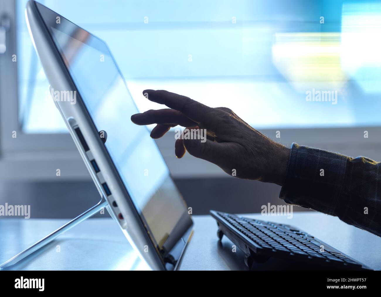 Main du technicien utilisant une tablette PC avec clavier au bureau à domicile Banque D'Images