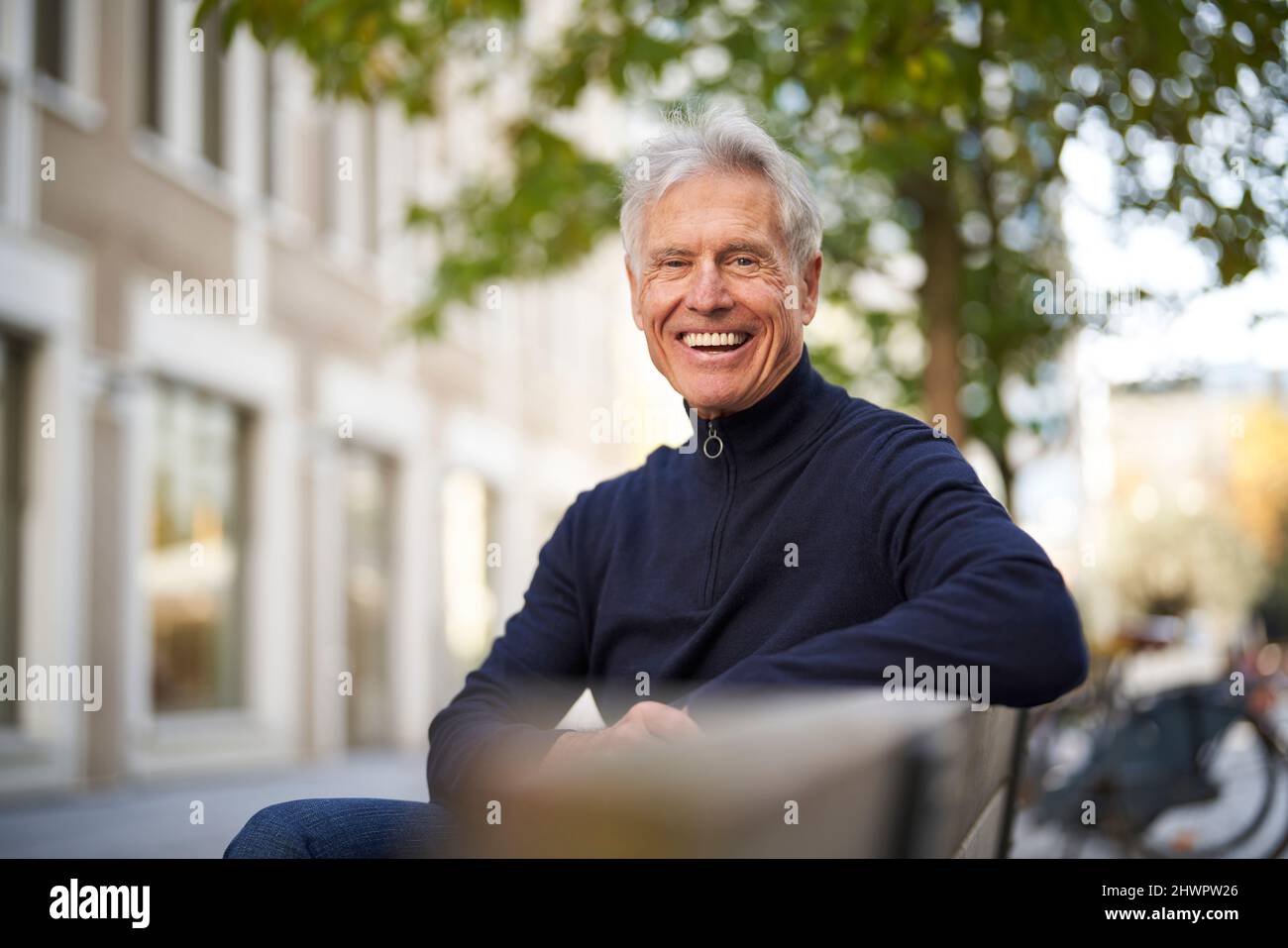 Homme de bonne humeur assis sur le banc Banque D'Images