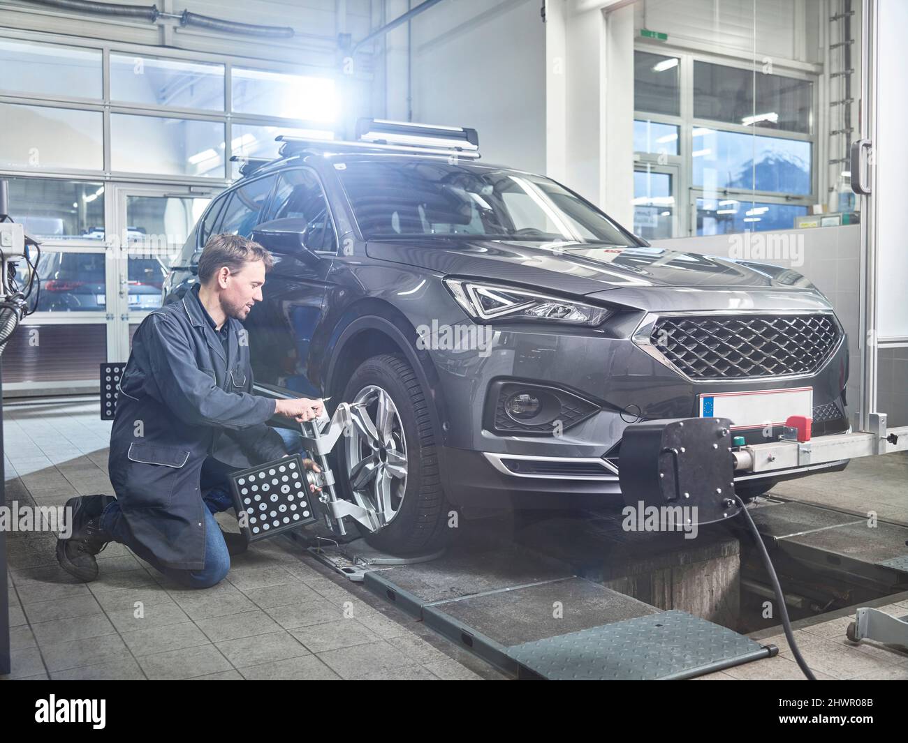 Un mécanicien examine les pneus à l'atelier de réparation automobile Banque D'Images