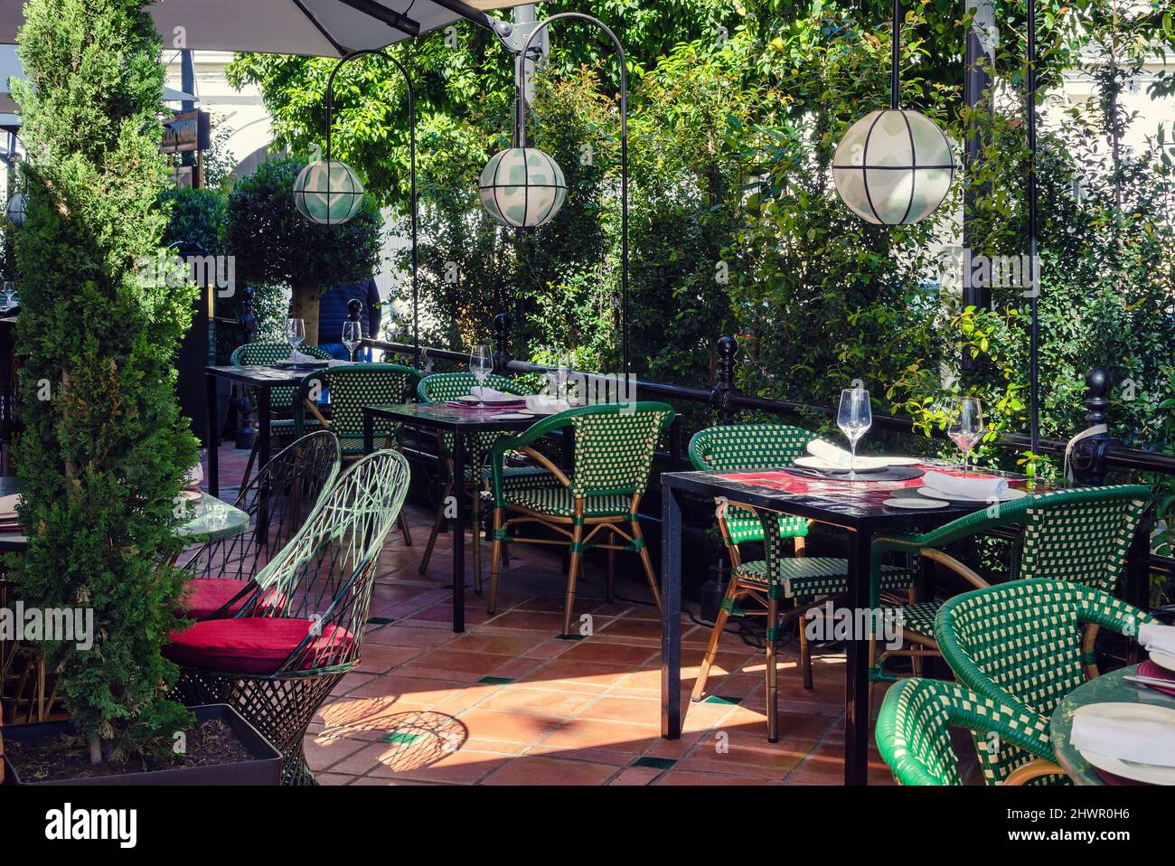 Terrasse extérieure de restaurant vide avec plantes naturelles, tables et chaises. Jour ensoleillé. Banque D'Images