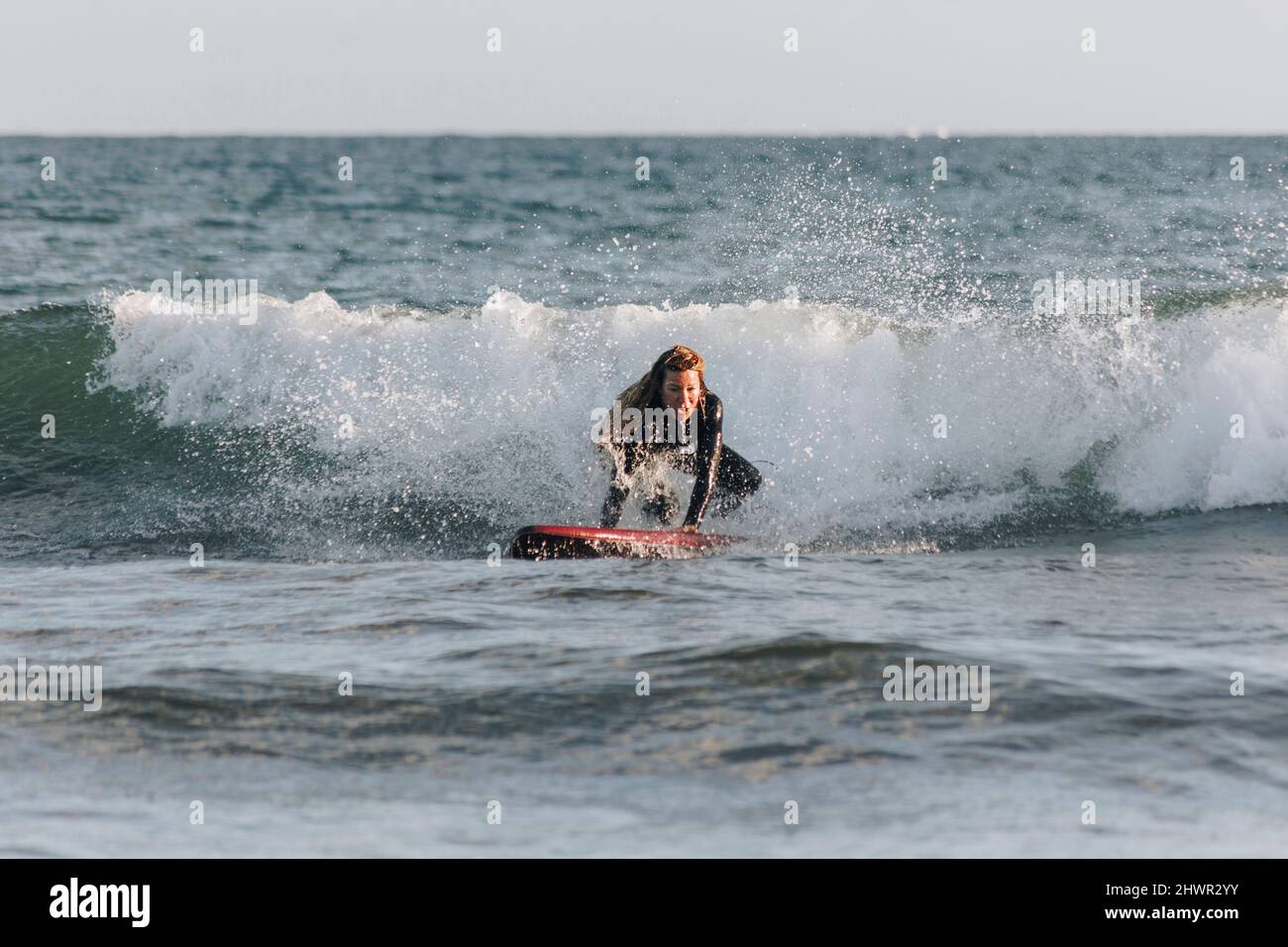 Déterminée femme surfant en face de la vague en mer, Gran Canaria, îles Canaries Banque D'Images