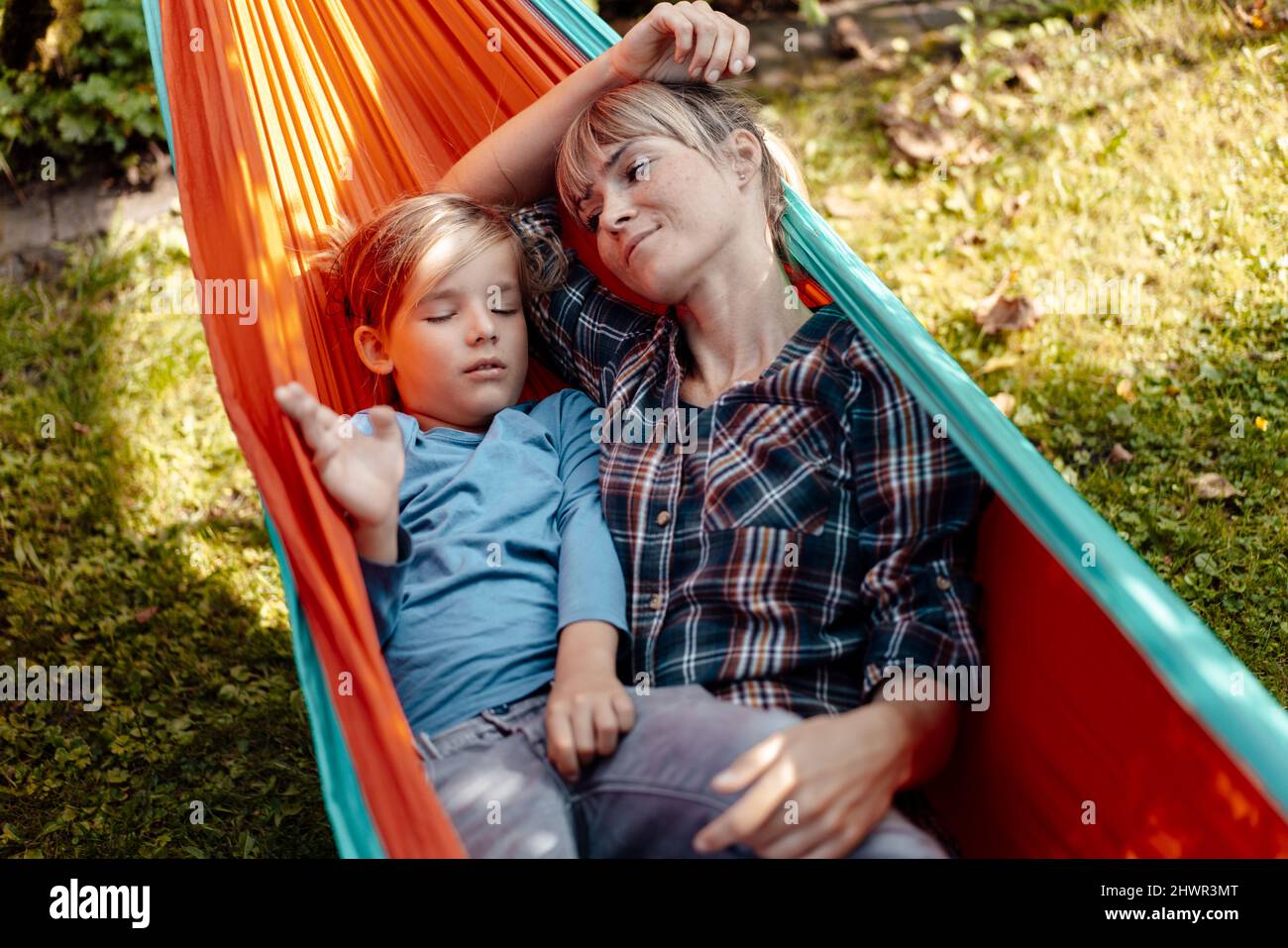 Mère regardant son fils dormant dans un hamac Banque D'Images