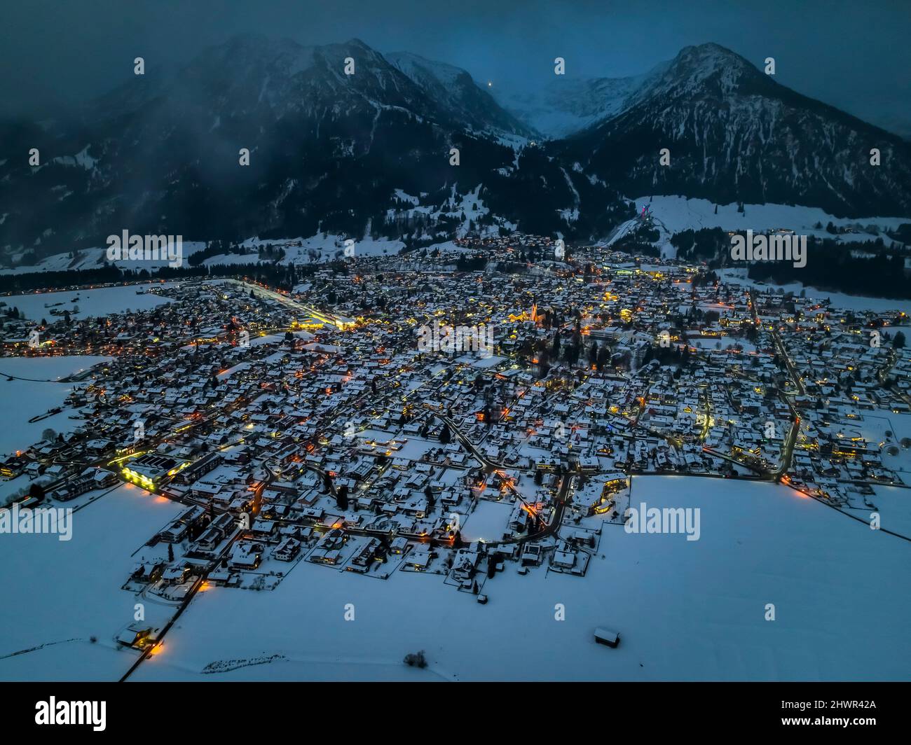 Allemagne, Bavière, Oberstdorf, vue en hélicoptère de la ville enneigée dans les Alpes d'Allgau au crépuscule Banque D'Images
