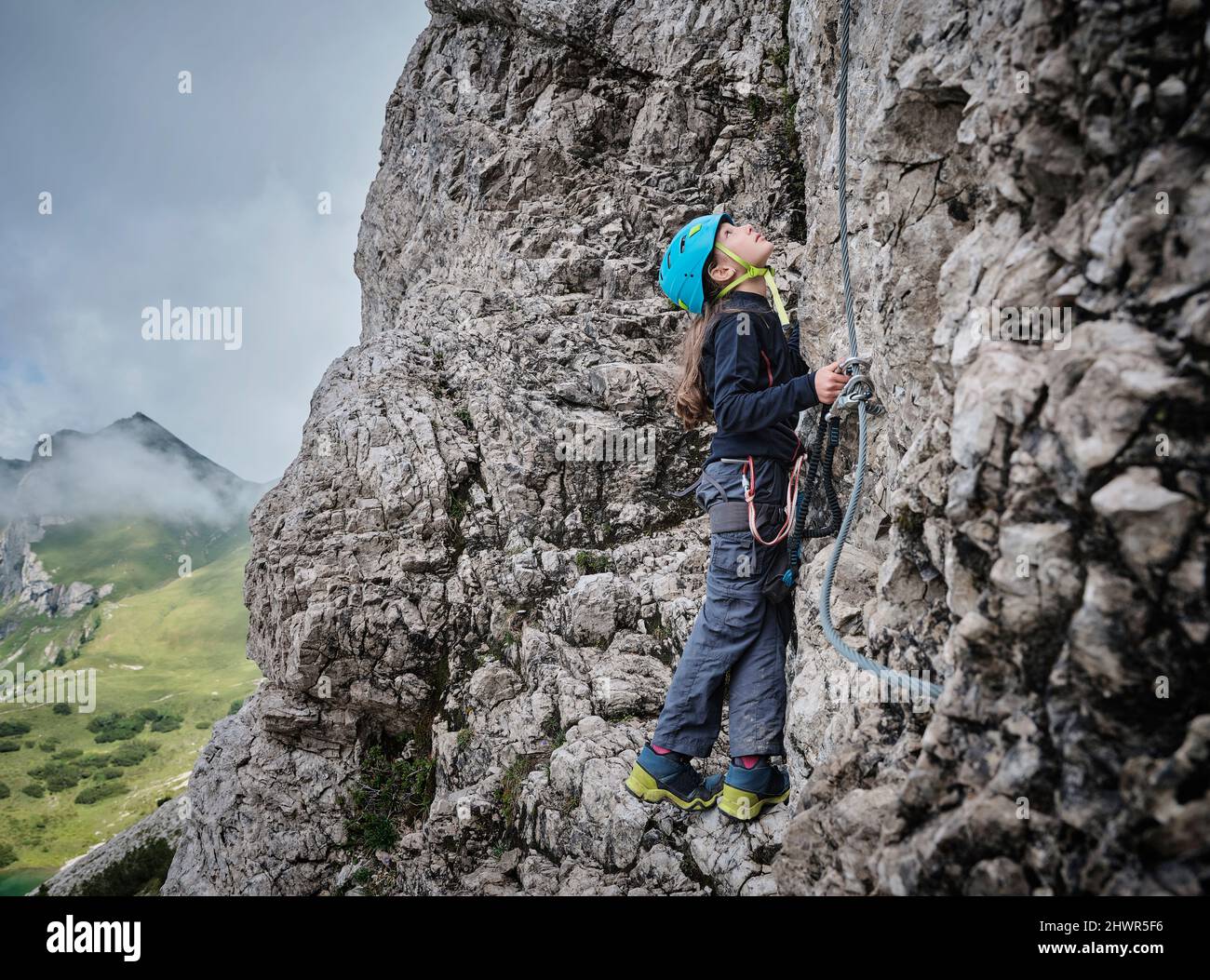 Fille portant un casque regardant sur la montagne rocheuse Banque D'Images