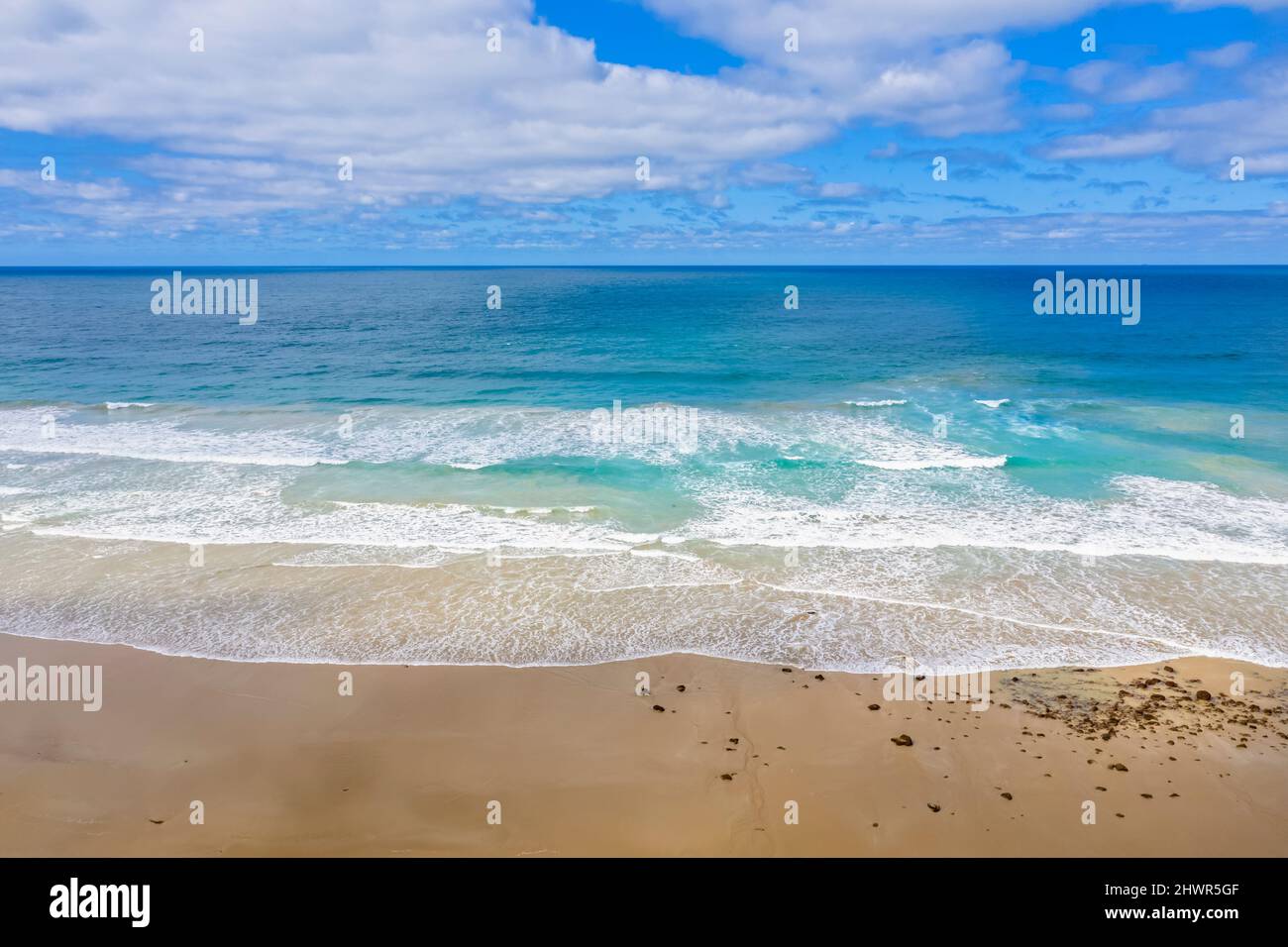 Australie, Victoria, vue aérienne d'une plage de sable le long de Great Ocean Road en été avec ligne d'horizon claire sur la mer en arrière-plan Banque D'Images