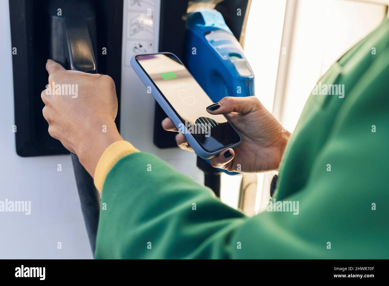 Commuter scannant le code QR sur le téléphone portable à la station-service Banque D'Images