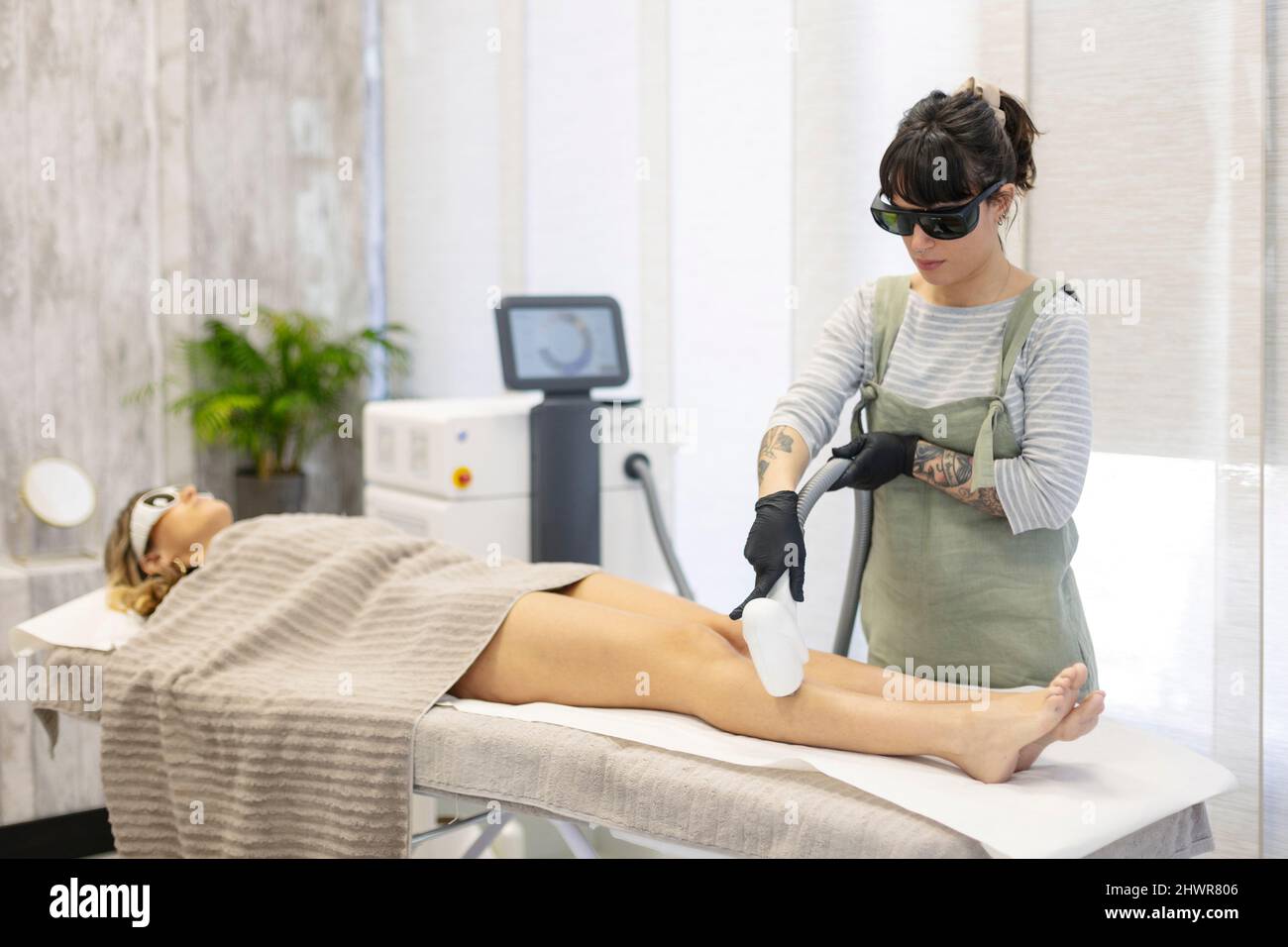 Esthéticienne utilisant l'enlèvement de cheveux laser machine sur la femme  à la clinique esthétique Photo Stock - Alamy