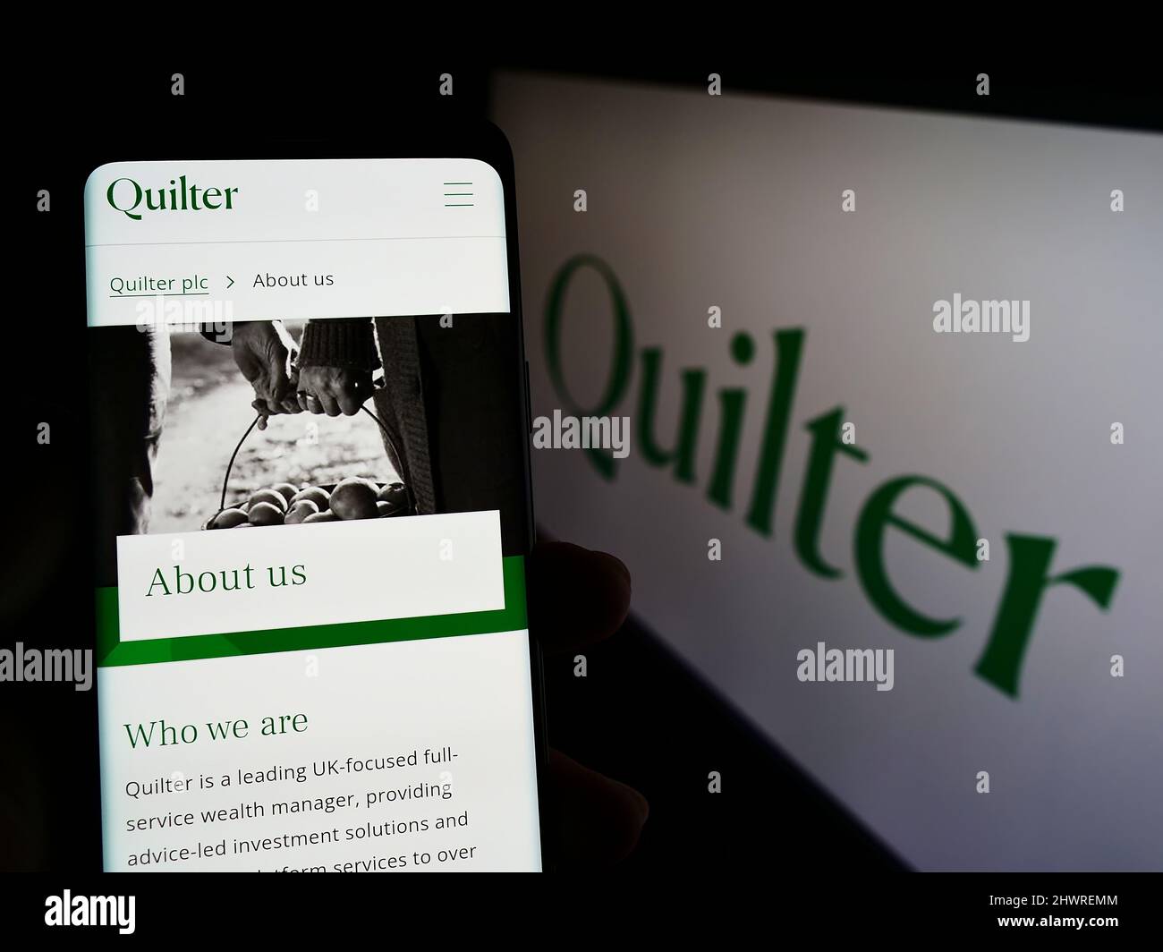 Personne tenant un smartphone avec la page Web de la société britannique de gestion de patrimoine Quilter plc à l'écran avec logo. Concentrez-vous sur le centre de l'écran du téléphone. Banque D'Images