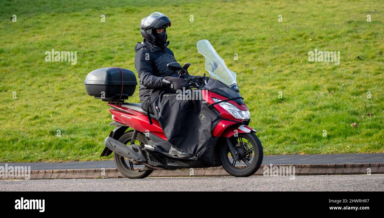 Honda PCX Scooter avec pilote utilisant des manchons de barre de Tucano et une protection de jambe Banque D'Images