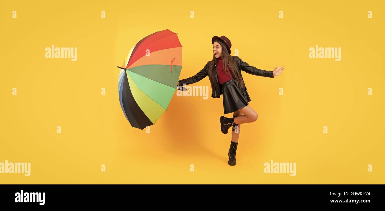 bonne fille de l'adolescence dans le chapeau et les vêtements en cuir ayant le plaisir avec le parapluie arc-en-ciel, la saison d'automne Banque D'Images