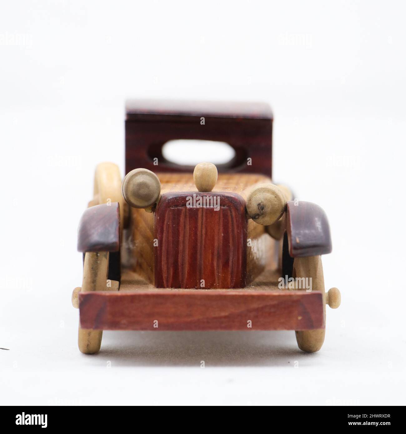 vue avant d'une voiture miniature en bois brun de modèle vintage isolée sur fond blanc Banque D'Images