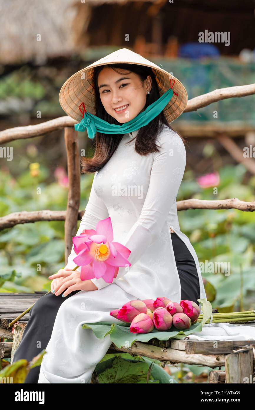 Portrait de la belle femme vietnamienne avec chapeau traditionnel vietnam  tenant le lotus rose marchant sur le pont en bois dans le grand lac de  lotus, vietnam, ai Photo Stock - Alamy