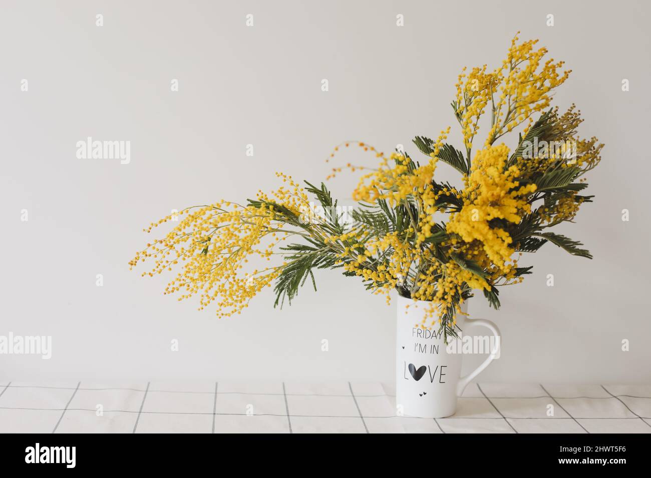 Bouquet Mimosa dans un vase sur fond clair avec espace de copie Banque D'Images