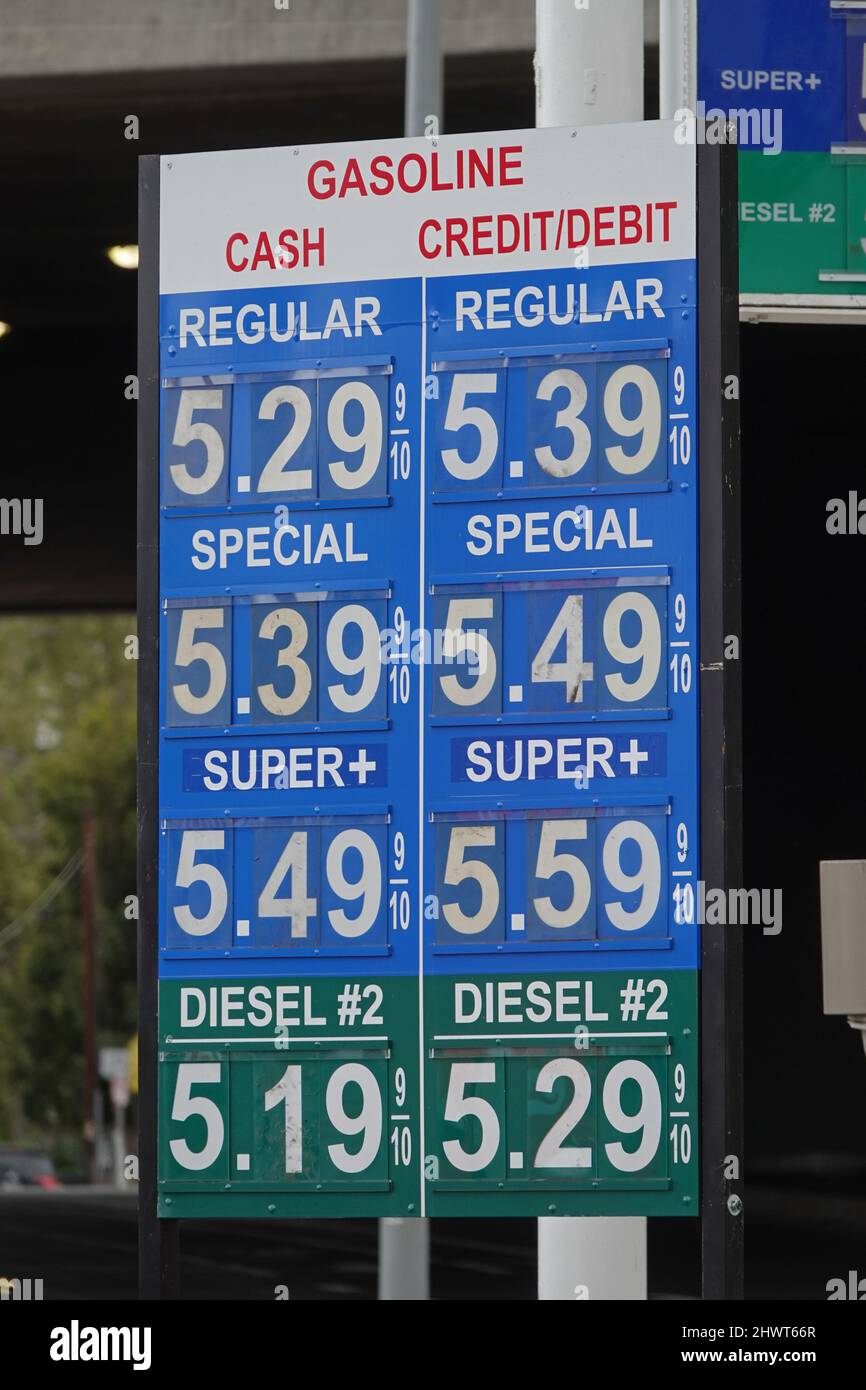 Un panneau de station-service affiche le prix actuel du carburant à plus de  $5 USD le gallon à côté d'une route aux États-Unis, pendant la journée,  dans une vue verticale Photo Stock -