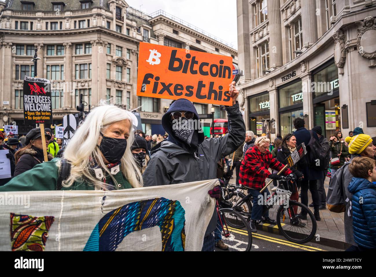 Homme masqué portant un écriteau en faveur du Bitcoin, manifestation Stop the War organisée par Stop the War Coalition, Londres, Royaume-Uni, 6th mars 2022 Banque D'Images