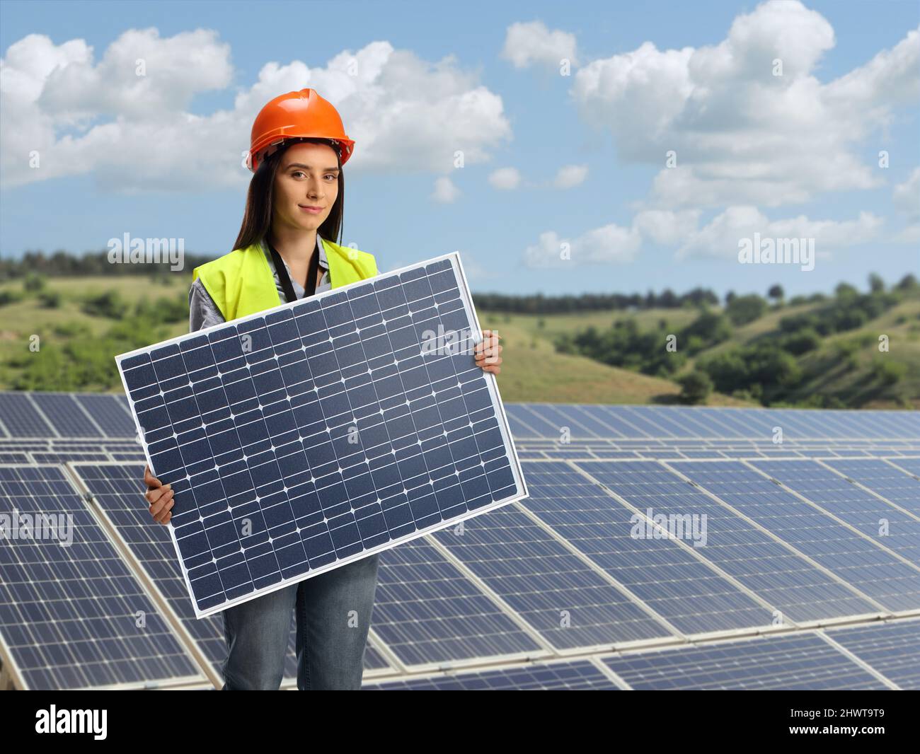 Jeune femme ingénieur tenant un panneau solaire photovoltaïque sur une centrale solaire photovoltaïque Banque D'Images