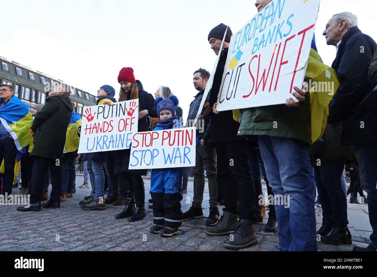 En raison de l'invasion de l'Ukraine par la Russie, une manifestation a eu lieu samedi à Linköping, en Suède, pour montrer son soutien aux victimes de la guerre. Sur la photo : des manifestants avec des signes sur le point de couper quelques banques russes de Swift. Banque D'Images