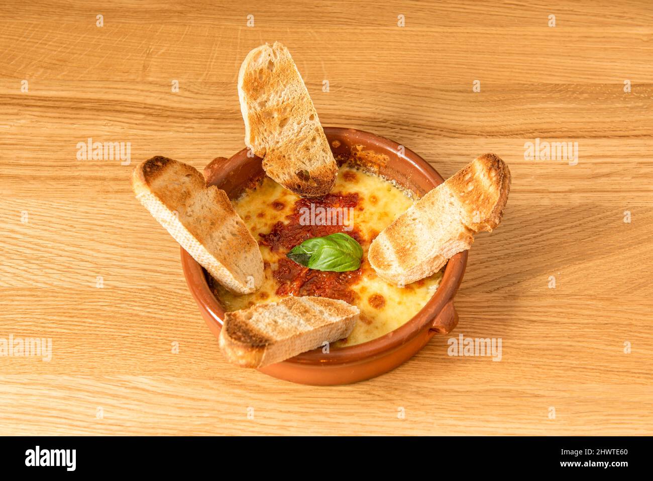 Provolone je le prépare dans le four, ... Le riche fromage fondu mélangé avec la sauce tomate italienne, un spectacle Banque D'Images