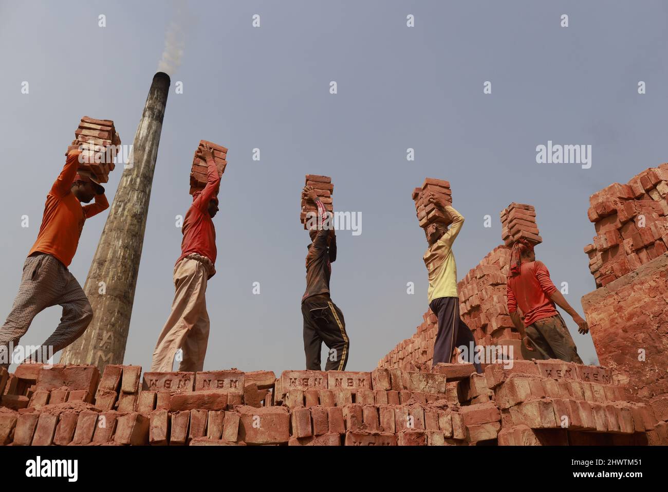 Keraniganj, Bangladesh. 07th mars 2022. Des bangladais travaillent dans un champ de briques à Keraniganj, près de Dhaka, au Bangladesh, le 7 mars 2022. L'émission d'une énorme quantité d'éléments toxiques dans les fours à briques entraîne de graves risques pour la santé des travailleurs et des personnes vivant dans les zones environnantes qui souffrent le plus de problèmes respiratoires ou de peau. Les travailleurs dans ce champ de brique gagnent moins de $5 par jour. (Photo de Suvra Kanti Das/Sipa USA) crédit: SIPA USA/Alay Live News Banque D'Images