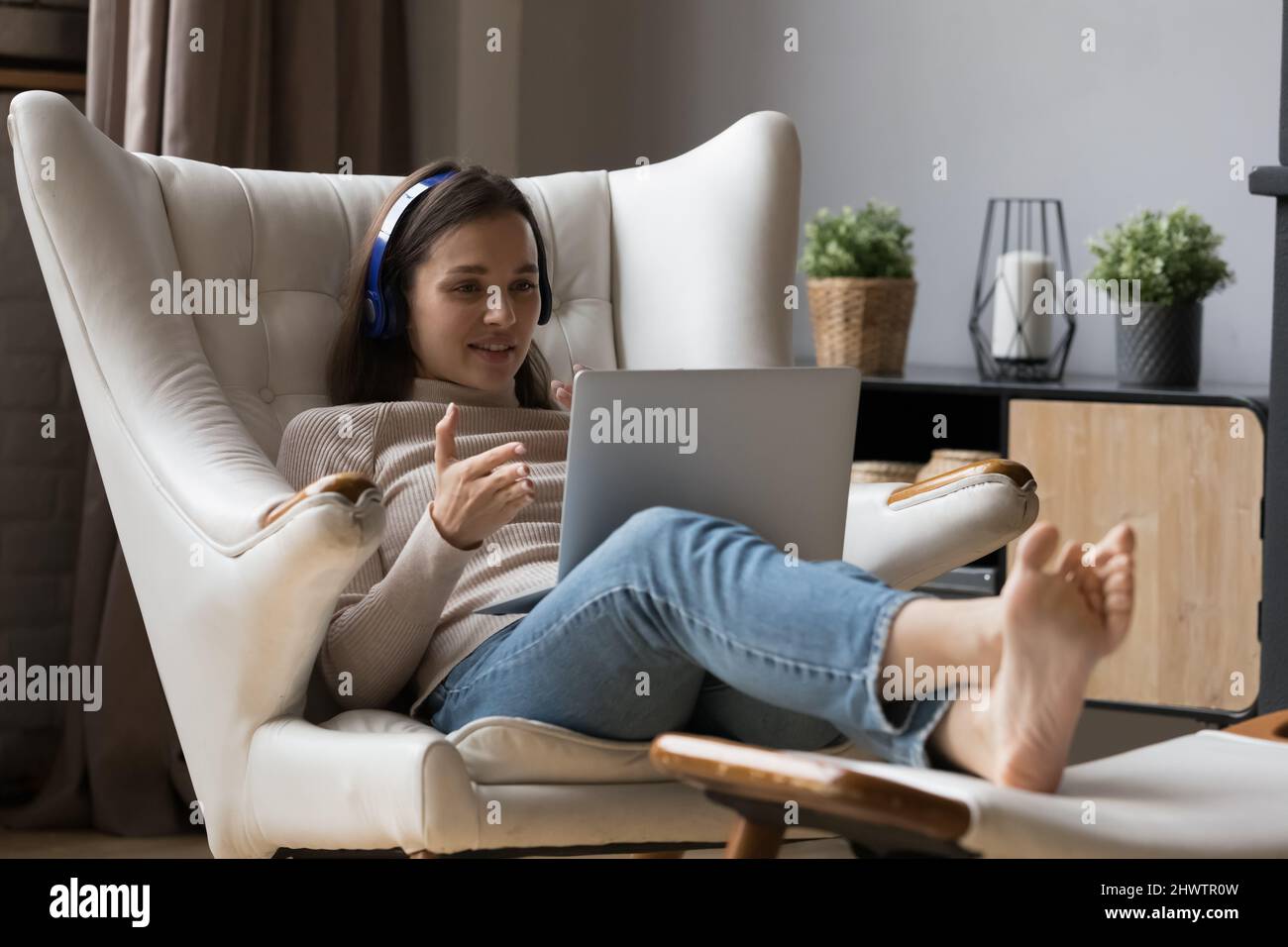 Une femme utilise un ordinateur portable pour parler à un ami par vidéoconférence Banque D'Images