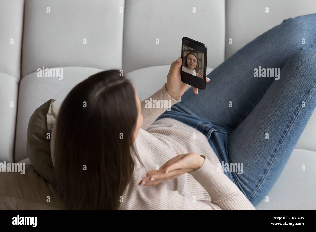 Une femme tient le téléphone portable regarde la caméra de l'appareil, enregistre la vidéo Banque D'Images