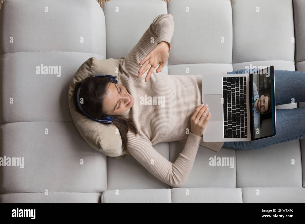 Femme saluant petit ami commencer videocall à l'aide d'un ordinateur portable Banque D'Images