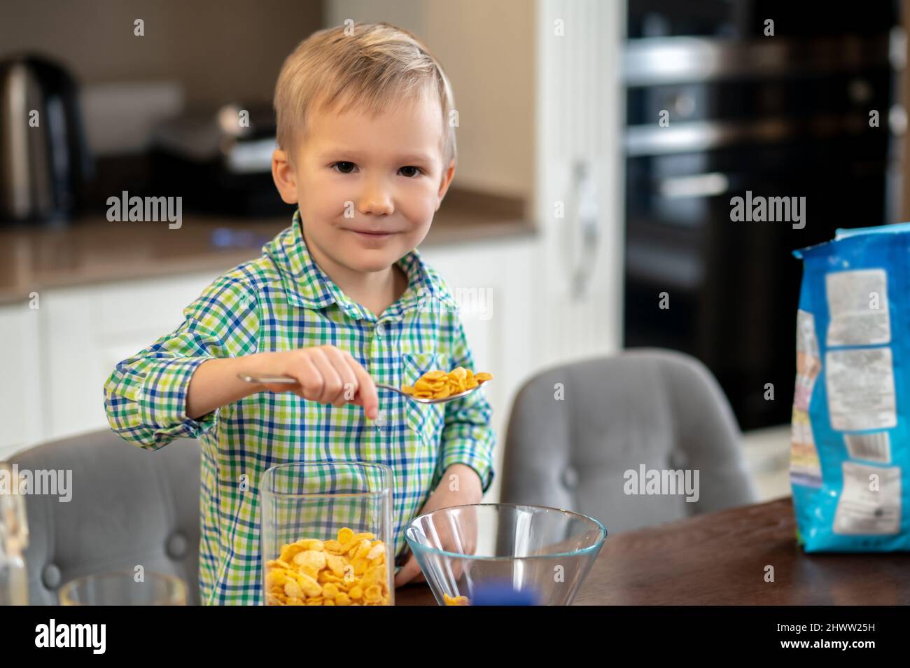 Enfant posant pour la caméra pendant son repas du matin Banque D'Images