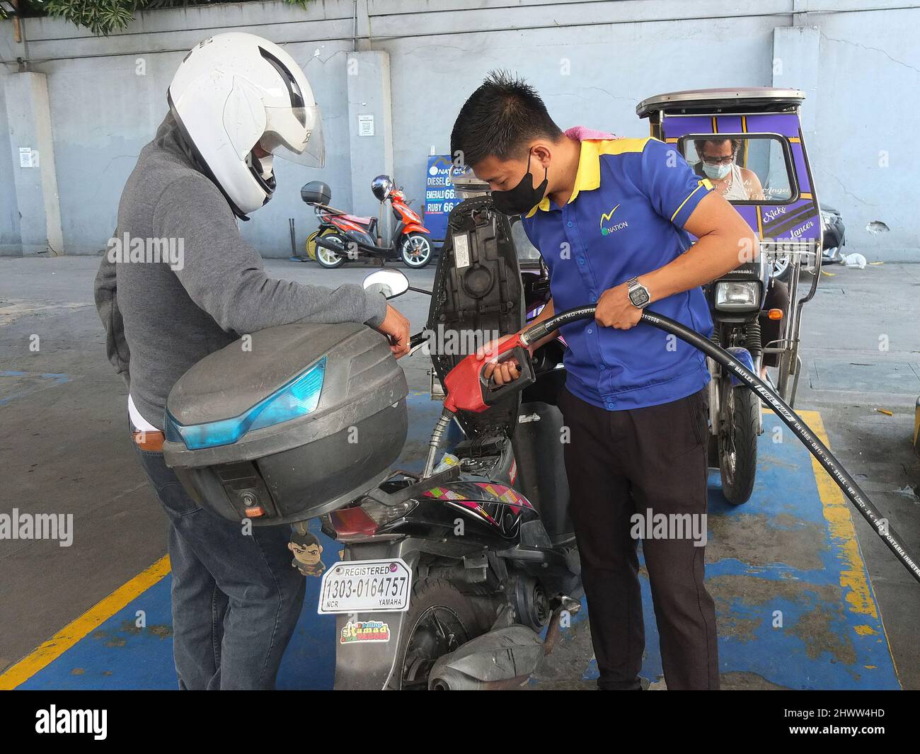 Caloocan, Philippines. 7th mars 2022. Un pilote de moto regarde sa moto en plein ravitaillement.les Philippines connaissent des prix élevés du pétrole et d'autres carburants dans le conflit entre la Russie et l'Ukraine. Le ministère de l'énergie avertit le public de se préparer à une augmentation du coût du carburant dans les jours à venir, et il a déclaré que cette répercussion sur les prix se produit non seulement aux Philippines, mais aussi dans d'autres parties du monde. Le Gouvernement philippin prépare un plan d'urgence pour subventionner les coûts du carburant pour le secteur des transports publics, les agriculteurs et les pêcheurs. (Image de crédit : © Josefiel Rive Banque D'Images