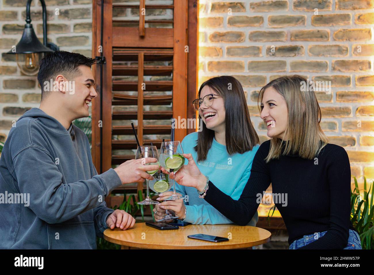 Les jeunes s'amusent dans un bar - des amis se sont amusés à boire des cocktails ensemble Banque D'Images