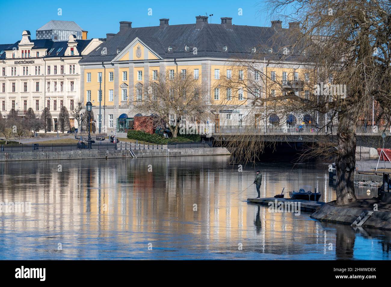 Homme pêchant sur la rivière Motala à Norrkoping au début du printemps. Norrkoping est une ville industrielle historique de Suède. Banque D'Images