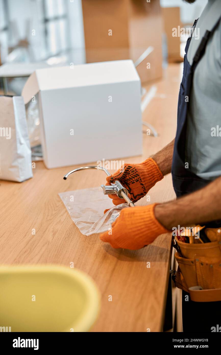 Les mains du réparateur tiennent la pièce métallique de la machine à café Banque D'Images