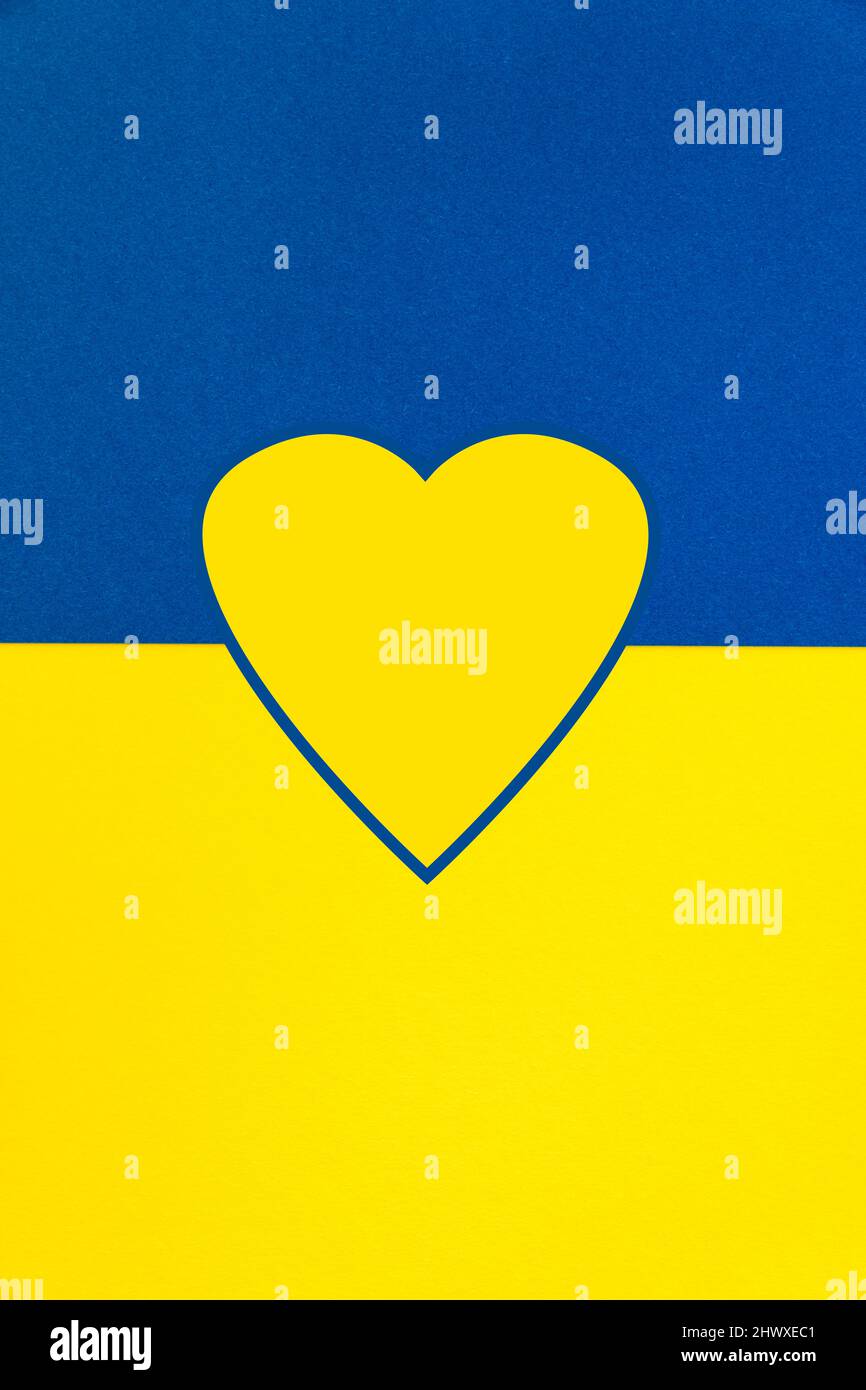 Portrait orantant fond avec la forme d'un coeur dans les couleurs nationales de l'Ukraine, bleu et jaune. Banque D'Images