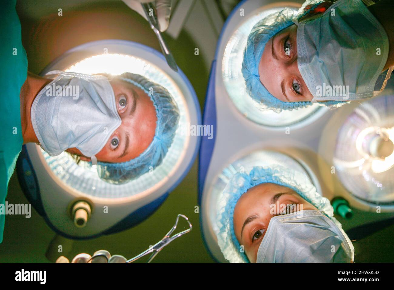 Vue des patients de l'équipe chirurgicale fonctionnant sous des lampes de théâtre (MODÈLE RELÂCHÉ) Banque D'Images