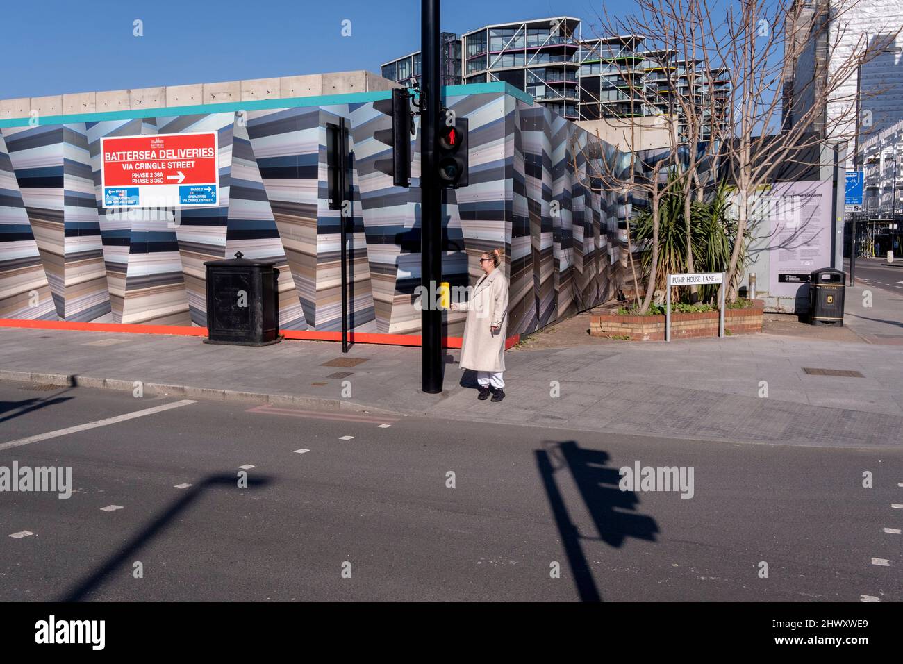 Un piéton marche à travers une construction urbaine de palissades et de