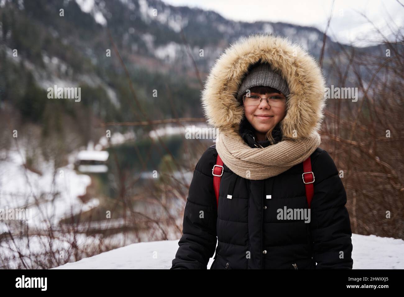 Jeune femme touriste en manteau d'hiver avec montagnes en arrière-plan  Photo Stock - Alamy
