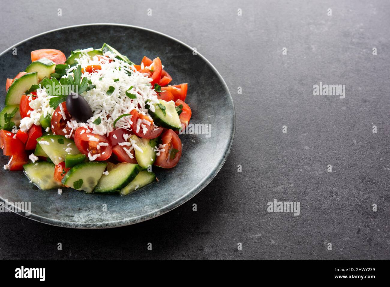 Salade traditionnelle bulgare shopska avec tomate, concombre et fromage bulgare sirene sur fond noir Banque D'Images