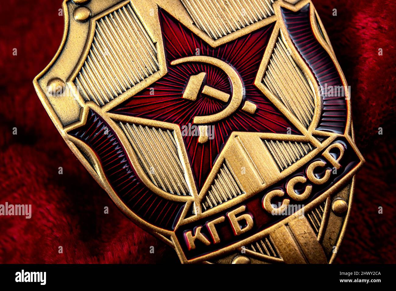 Service secret, agence de renseignement et concept d'espionnage avec macro gros plan sur un insigne du KGB de l'époque de la guerre froide de l'ex-URSS sur fond rouge Banque D'Images