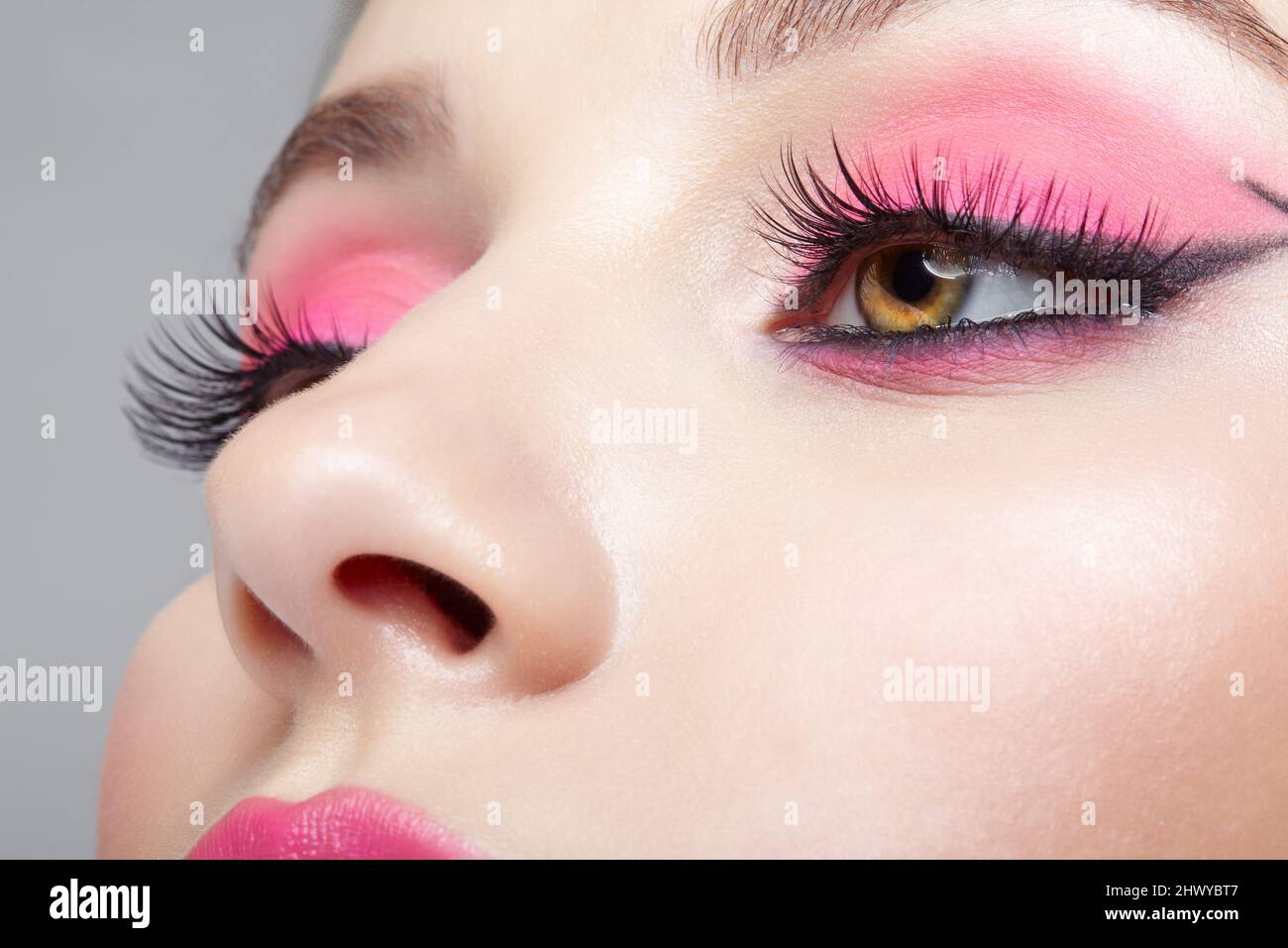 Gros plan sur le visage féminin humain. Femme avec une apparence orientale  et rose yeux et lèvres beauté maquillage Photo Stock - Alamy