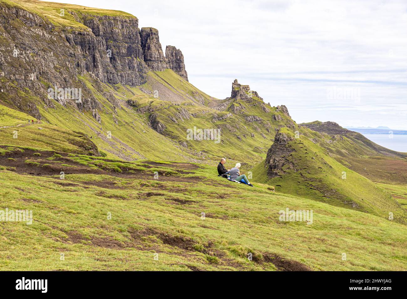 Un couple d'âge moyen appréciant la vue sur la promenade de Quiraing dans le nord de l'île de Skye, Highland, Ecosse Royaume-Uni. Banque D'Images
