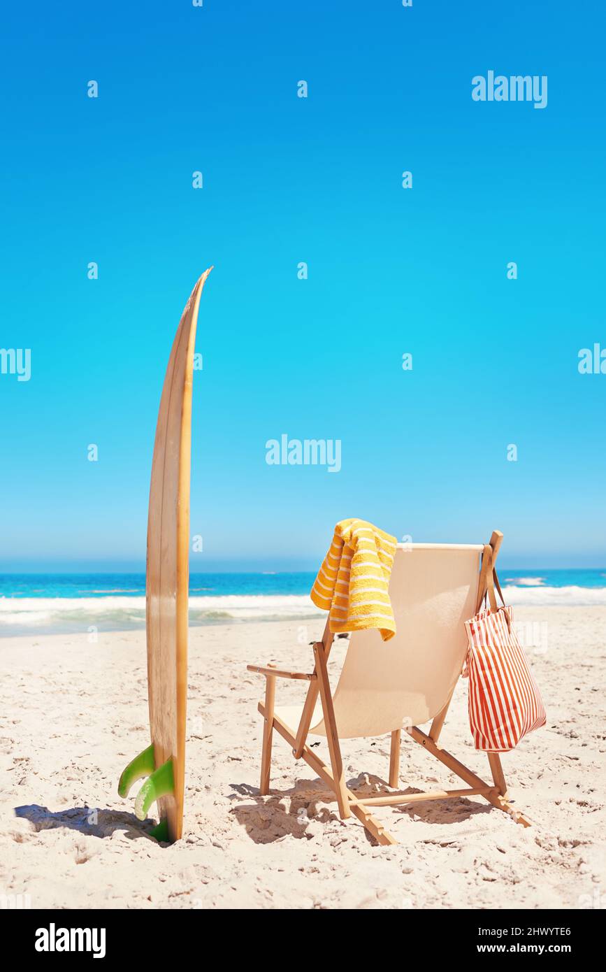 Prêt pour les vagues. Photo d'une chaise longue et d'une planche de surf sur la plage. Banque D'Images