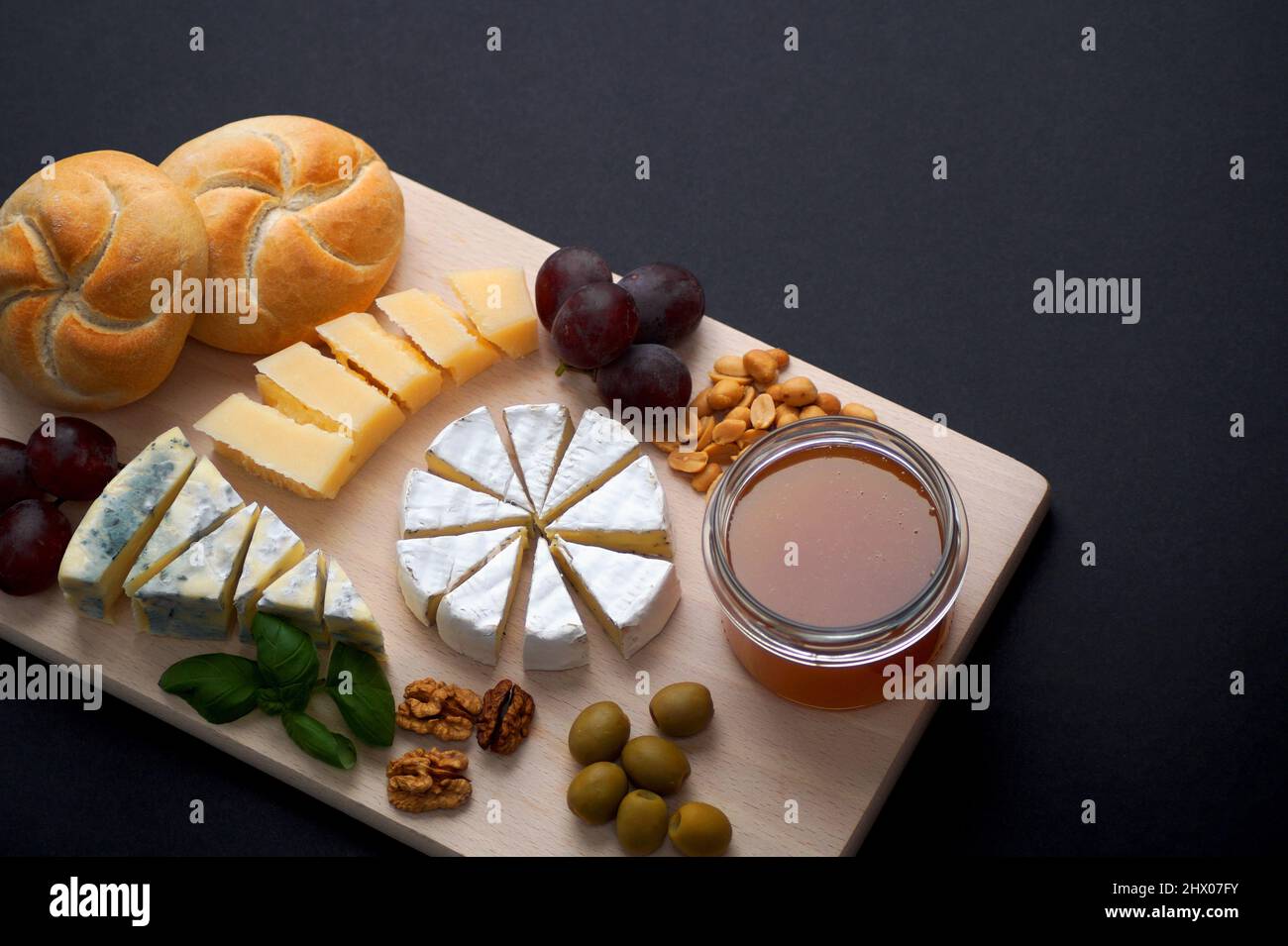 assortiment de tranches de ​​cheeses - camembert brie, camembert bleu et parmesan empilés sur une planche Banque D'Images