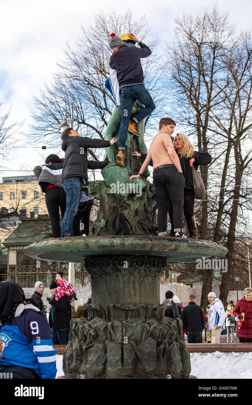 Des jeunes grimpent sur la sculpture en bronze Havis Amanda pour célébrer la médaille d'or du hockey olympique à Helsinki, en Finlande Banque D'Images