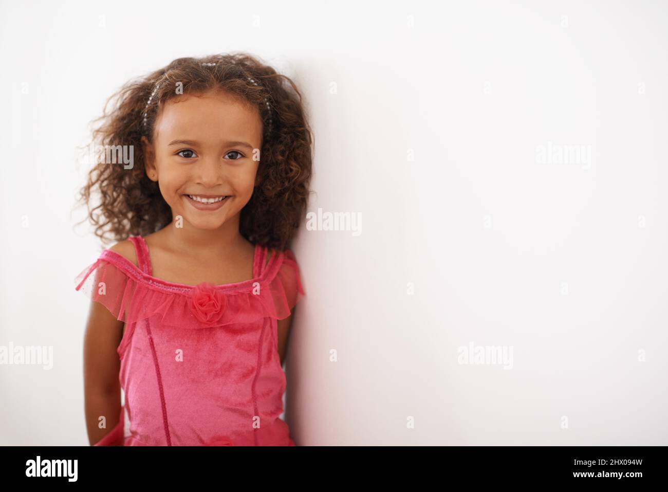 Je suis une princesse de fées. Portrait d'une petite fille dans une robe rose souriant à l'appareil photo. Banque D'Images