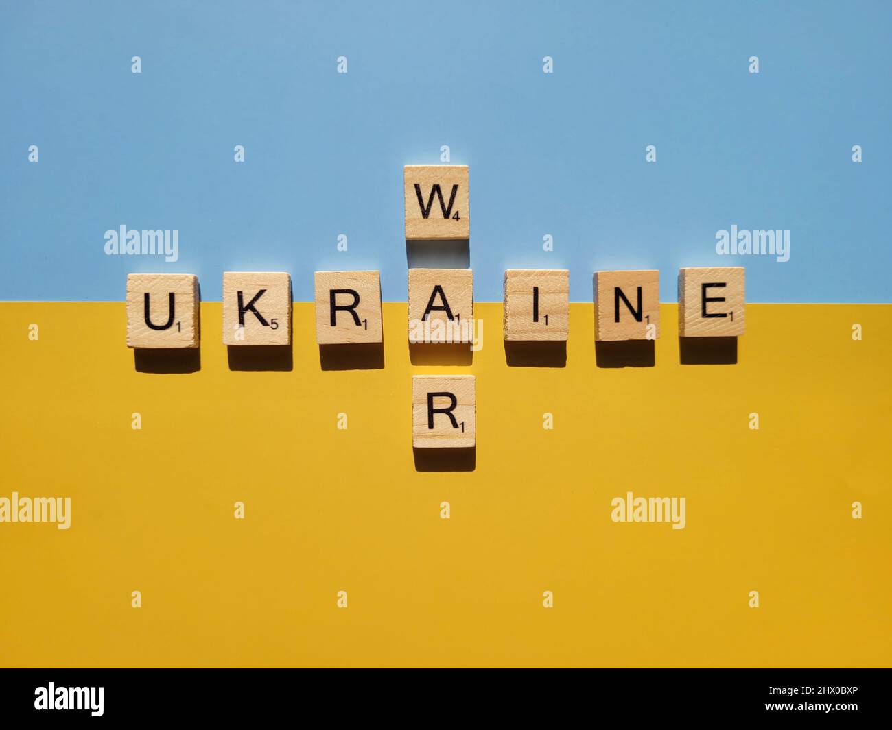 Gros plan sur des mots sur des lettres de l'alphabet en bois sur fond jaune et bleu. Pose à plat. Concept de liberté et de soutien de l'Ukraine. Action de protestation. Arrêter la guerre. Banque D'Images