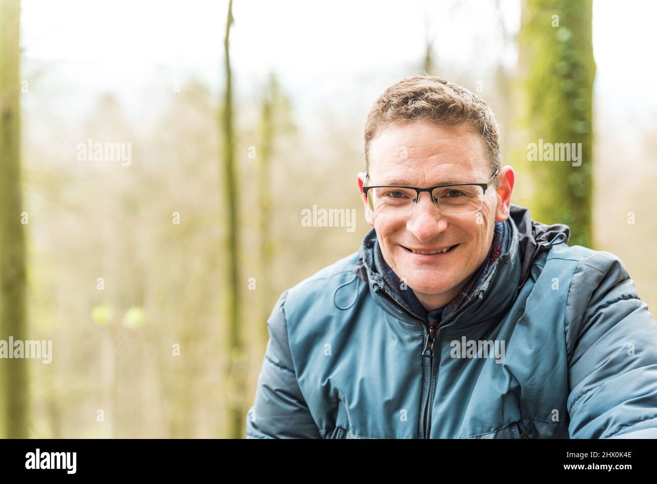 Kordel, Rhénanie-Palatinat - Allemagne - 04 13 2019 - gros plan portrait d'un homme blanc souriant de quarante ans avec des lunettes et un jacke bleu de mi-saison Banque D'Images