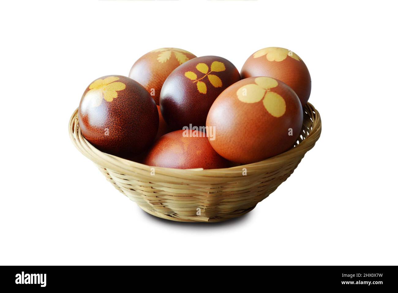 Panier de Pâques avec œufs naturellement teints et peaux d'oignons isolées sur fond blanc Banque D'Images
